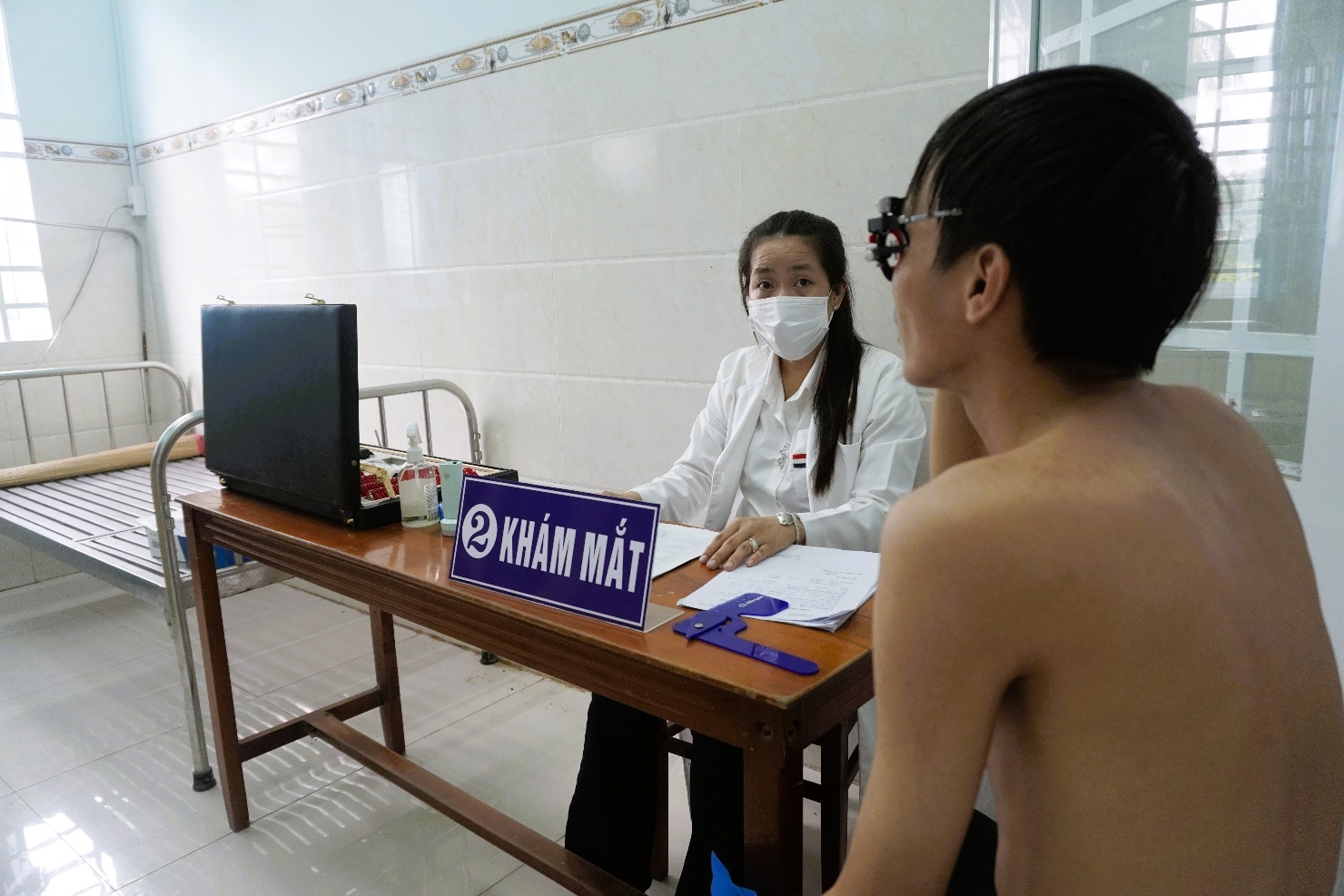 Description: A person wearing a mask and sitting at a desk
AI-generated content may be incorrect.