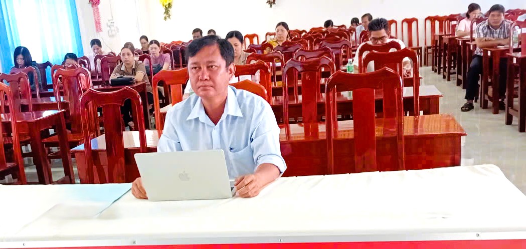 Description: A person sitting at a table with a computerAI-generated content may be incorrect.